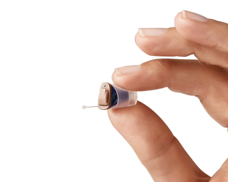 Homem segurando aparelho auditivo IIC